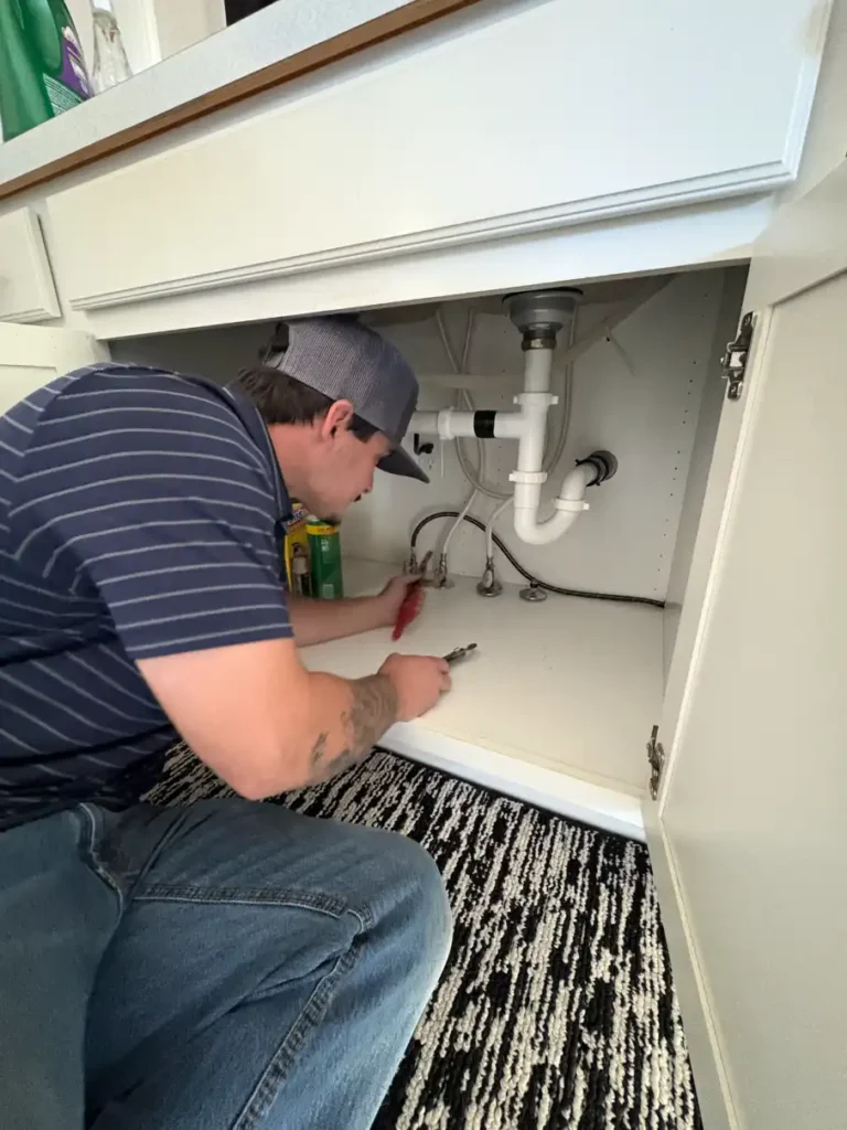 A man working in a kitchen sink.